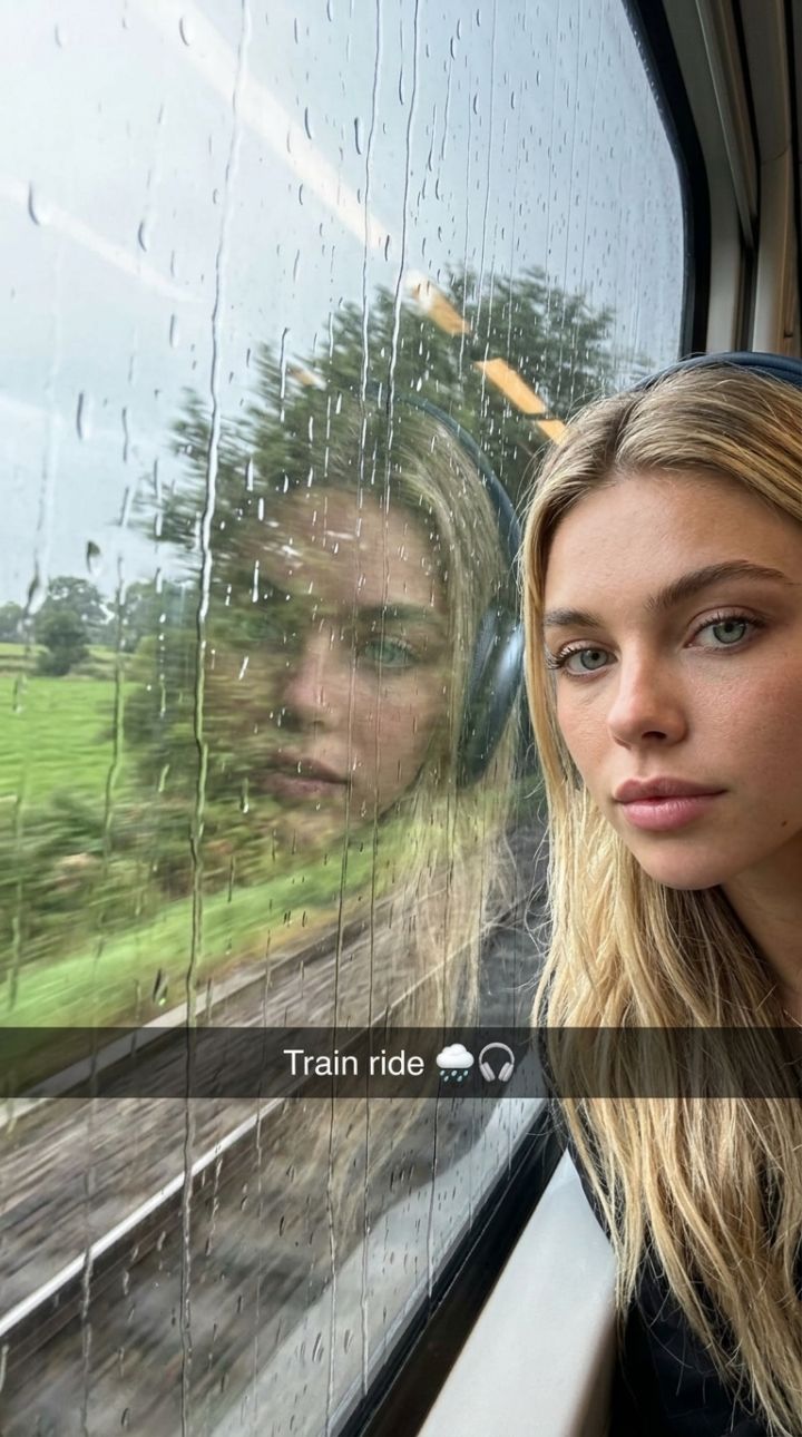 Foto Spontan di Kereta: Pantulan Wajah Headphone di Jendela Hujan Buram