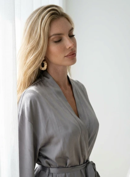 A serene close-up portrait captured in soft morning light streaming through gauzy curtains, face gently turned to the...