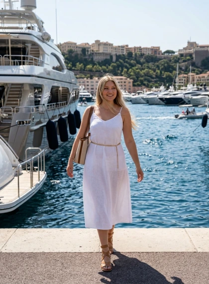 Enesekindel naine Port Hercules'i jahisadamas valges lina suvekleidis