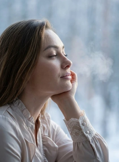 Portrait in profile, head slightly tilted, leaning on hand, eyes half-closed in calm, cool morning light penetrates t...