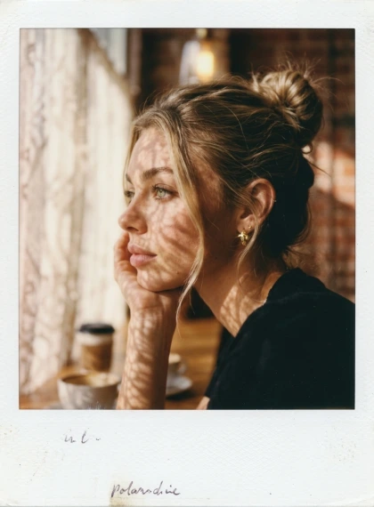 Thoughtful profile, chin on hand, soft daylight penetrates through the curtains, creating shadow patterns on the face...