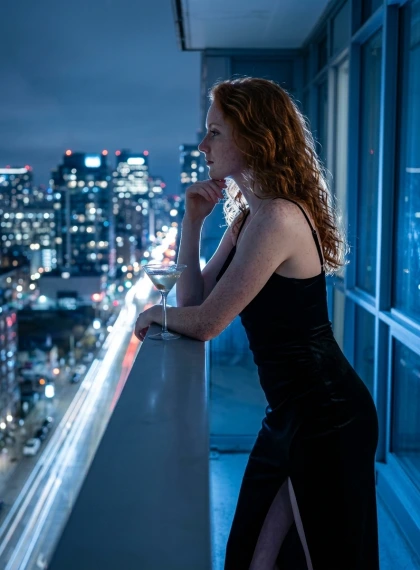 Thoughtful Silhouette Woman in Black Velvet Cocktail Dress on City Skyline Balcony